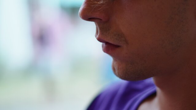 Young man thinking in profile, showing serious facial expression and unshaven chin