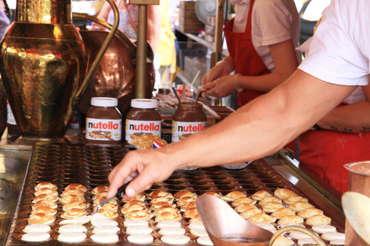 Manos de personas preparando gofres con nutella