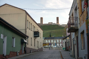 Fototapeta premium Staszica Street leads to main town square. Towers of Upper Castle in background. Chęciny, Poland.