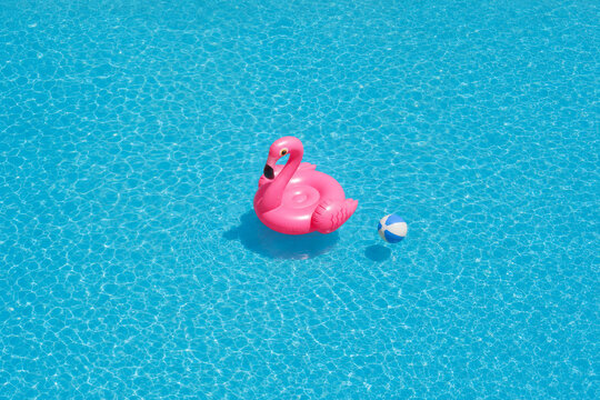 Pink flamingo float in blue swimming pool water
