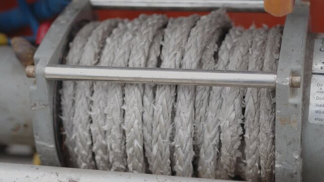  Cinematic close-up of a rugged off-road winch pulling synthetic rope