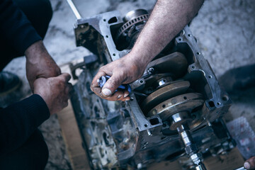 Fototapeta premium Close-up of the hands of a car mechanic repairing a car engine