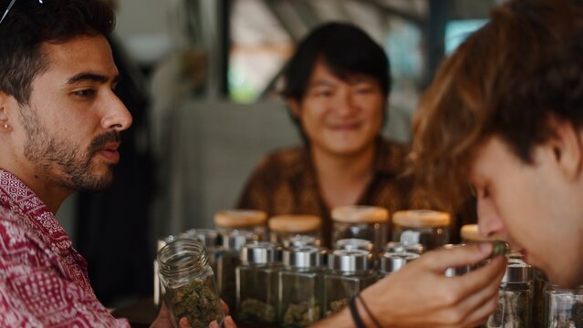Customers choosing cannabis products, smelling marijuana bud in a legal dispensary