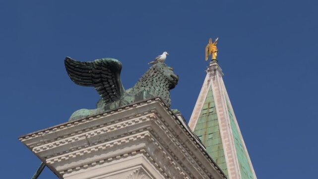 Seagull Perched on Winged Lion Statue in Cloudy Venice