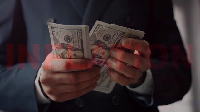 Close-up of a businessman counting US dollar bills with a red grid and the word "INFLATION" overlaid, symbolizing economic pressure. 