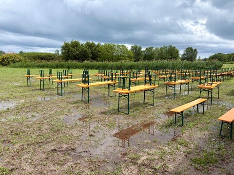 Ins Wasser gefallen, Biertischgarnituren auf einer nassen Wiese