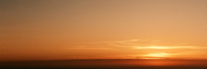 Fototapeta premium Captivating Sunset Horizon: Orange and Golden Hues in a Serene Evening Landscape