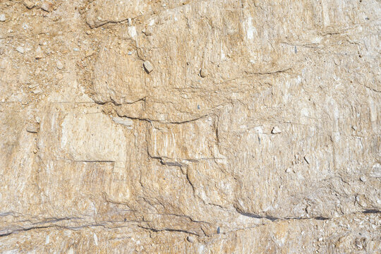 Close-up of natural rock texture with rough stone surface and detailed geological structure, abstract beige background ideal for design, backdrop, wallpaper or graphic composition