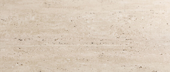 Travertine marble background shows a beige stone surface with subtle natural pits and lines © UmmeFarhatunnesa