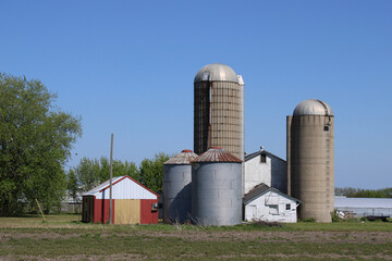 Abandoned farm in Mount Pleasant, Wisconsin with two grain bins and a pair of concrete tower silos © John