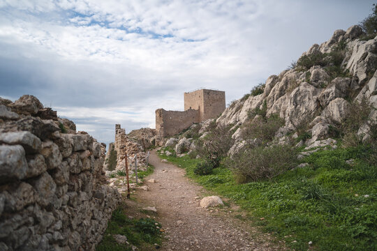 Ancient ruins of Acrocorinth castle with stone wall and pathway in Greece