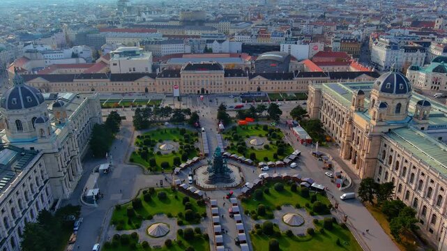 4K aerial view of Maria-Theresien-Platz with Empress monument, twin Kunsthistorisches and Naturhistorisches museums, Christmas market stalls and Museumsquartier in autumn Vienna.