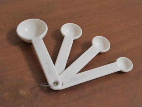 White Measuring Spoons on Wooden Table