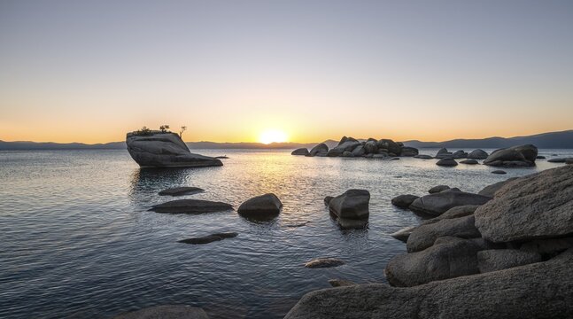 Lake shore, Bonsai Rock, small tree on a rock in the water at sunset, round stones in the water, Lake Tahoe, California, USA