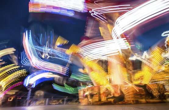 Scattered light trails from a fairground ride at night, Munich Spring Festival, Theresienwiese, Munich, Bavaria, Germany