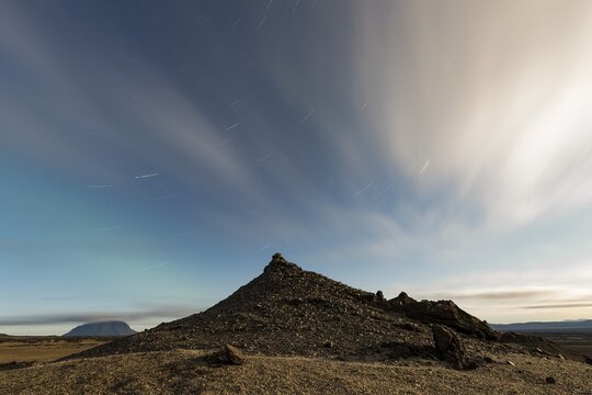 Faint northern lights (Aurora Borealis) and star trails, in the background table volcano Her&eth;ubrei&eth; or Herdubreid, Icelandic highlands, Iceland