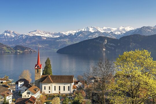 Holiday destination on Lake Lucerne with the parish church of St. Mary behind the snow-covered Alps, Weggis, Canton Lucerne, Switzerland