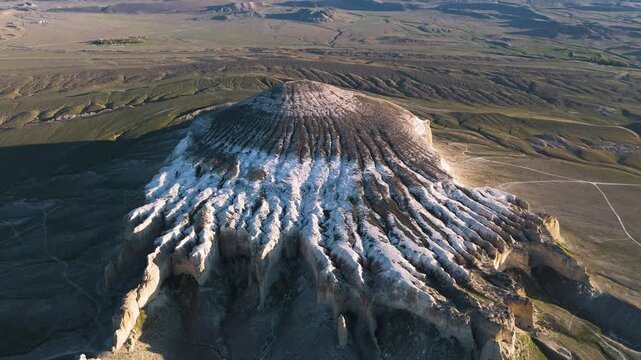 Drone flight around Mount Sherkala in Mangystau. The footage shows rugged cliffs on one side and an unusual yurt shape on the other. Desert landscape, wild nature, Martian landscapes, unique geology 