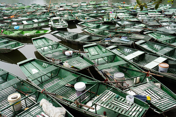 Close view of green rowing boats clustered on river at Tam Coc Vietnam © Sanand