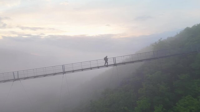 Walking on the Geierlay Bridge in Mosel Germany during a foggy morning