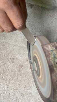 Close-up video of a hand using a grinder to sharpen a knife, showing tool maintenance, metal work, practical repair, and workshop craftsmanship.