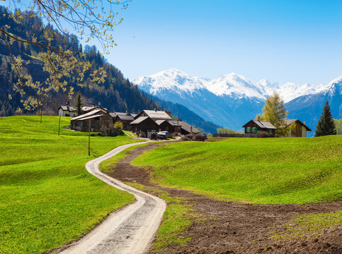 Small village against the backdrop of the Swiss Alps in late spring, Bodmen, Valais, Switzerland. View from hiking trail.