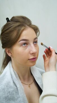 Beauty salon and makeup. Women's Hair Salon. The stylists at the women's salon are working with a young woman - vertical video