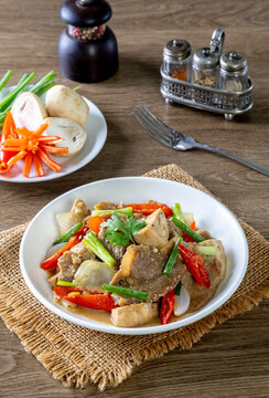 Saut&eacute; the meat in oil in a white plate on a wooden table.