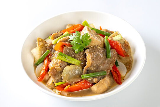 Saut&eacute; the meat in oil in a white plate on a white background.