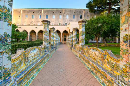 The famous Cloister of Santa Chiara with ornate ceramic tiled columns and benches in the historic center of Naples, Italy