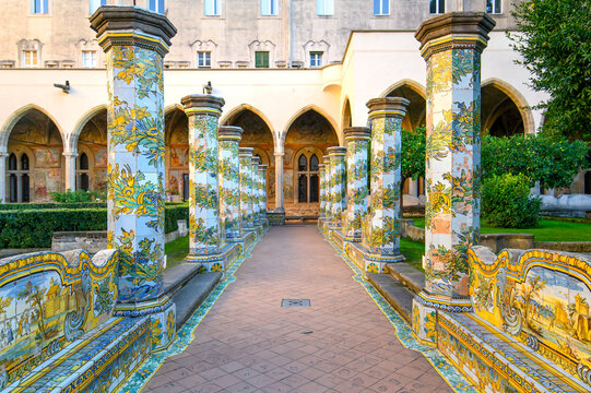 The famous Cloister of Santa Chiara with ornate ceramic tiled columns and benches in the historic center of Naples, Italy