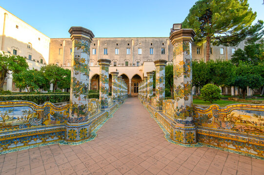 The famous Cloister of Santa Chiara with ornate ceramic tiled columns and benches in the historic center of Naples, Italy