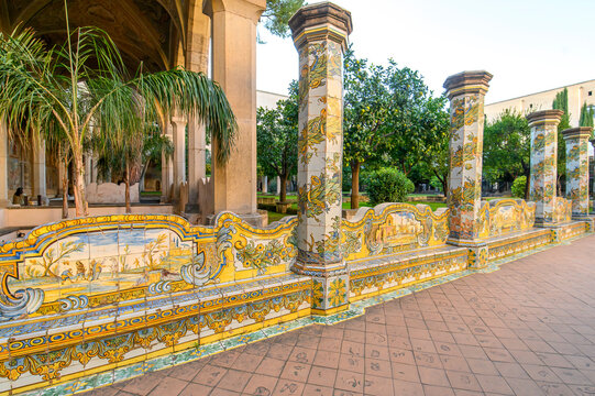 The famous Cloister of Santa Chiara with ornate ceramic tiled columns and benches in the historic center of Naples, Italy