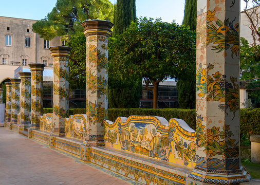 The famous Cloister of Santa Chiara with ornate ceramic tiled columns and benches in the historic center of Naples, Italy
