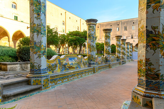 The famous Cloister of Santa Chiara with ornate ceramic tiled columns and benches in the historic center of Naples, Italy