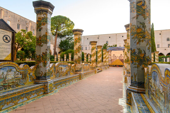 The famous Cloister of Santa Chiara with ornate ceramic tiled columns and benches in the historic center of Naples, Italy