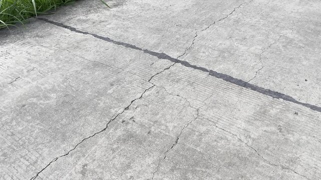 Abstract texture of broken concrete highway with distinct crack lines