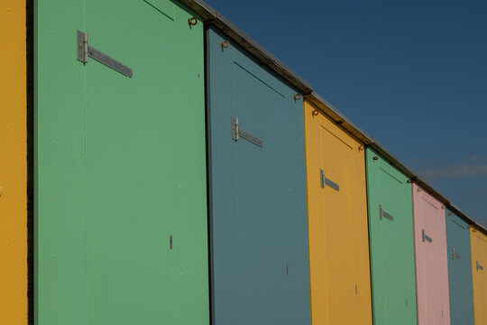 abstract minimalist background with pastel row of beachhouses in blue, green and yellow