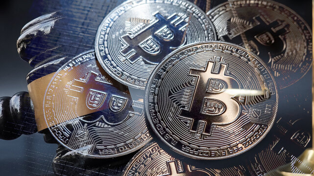 Double exposure image of Bitcoin cryptocurrency coin combined with a judge gavel and scales of justices, Digital assets law, Blockchain compliance, financial risk, and crypto investment.