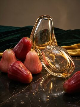 Still life composition with fresh rose apples and decorative glass vases