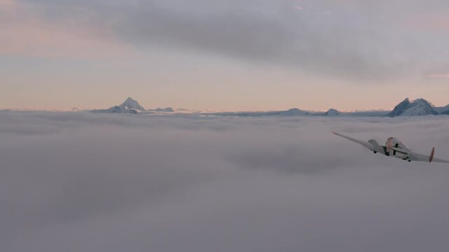 Vintage twin engine aircraft flying over a sea of clouds with snowy mountain peaks in the distance