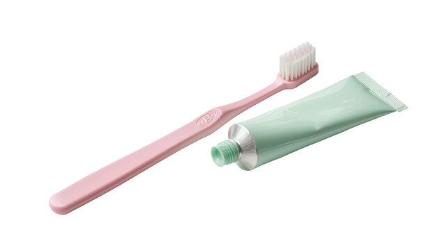 Isolated pink toothbrush and light green tube of toothpaste for a fresh oral hygiene routine