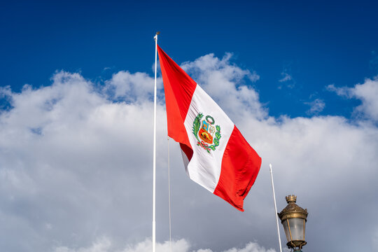 Peruvian National Flag Waving Against a Bright Blue Sky