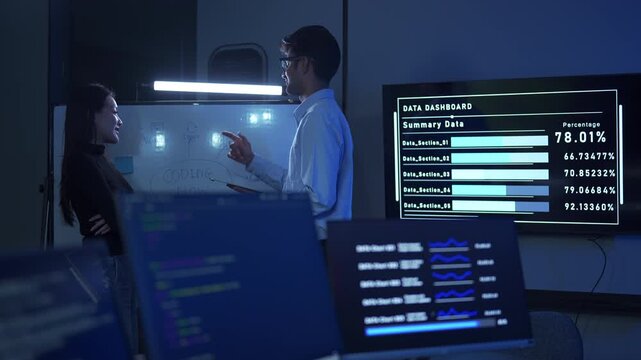 Two diverse programmers brainstorming together on a coding project in a modern office.