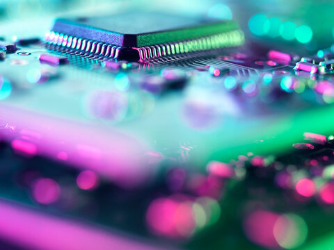 Macro close up of glowing microchip on an electronic circuit board