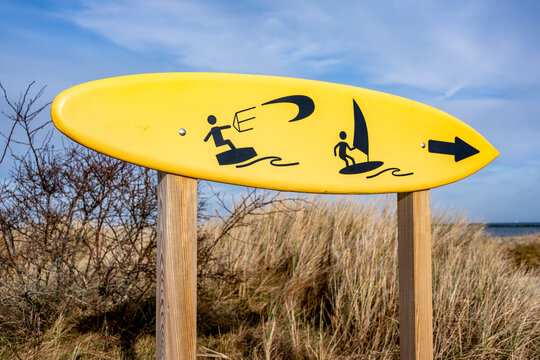 Yellow surfboard sign for kite and windsurfing at the beach