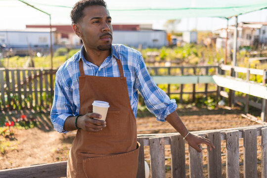 Farmer in apron taking a coffee break at the rural farm