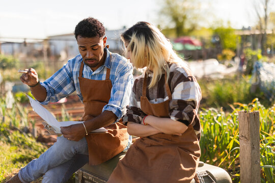 Couple discussing agriculture plans on a clipboard outdoors