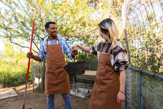 Couple gardening together outdoors wearing brown aprons