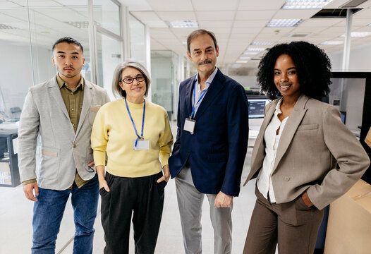 Portrait of multicultural colleagues standing in modern office